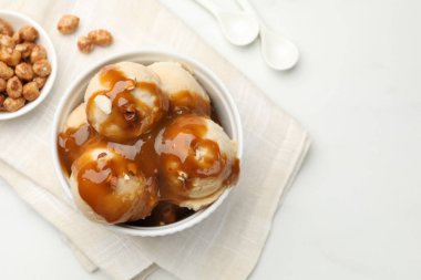 Karamel soslu lezzetli dondurma, badem ve beyaz masada patlamış mısır. Metin için boşluk