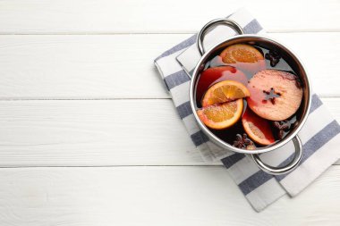 Beyaz ahşap masada, tencerede leziz bir şarap, üst manzara. Metin için boşluk