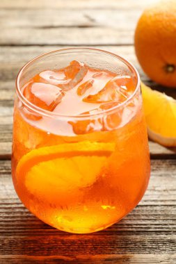 Bir bardak serinletici spritzer kokteyli ve portakallar ahşap masada, yakın plan.