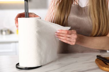 Mutfaktaki beyaz mermer masada kağıt havlu kullanan kadın, yakın plan.