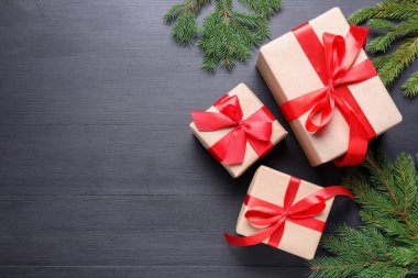 Noel hediyeleri ve siyah ahşap masa üzerindeki şenlikli dekor, düz yatış. Metin için boşluk