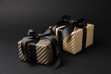 Siyah arkaplanda güzel paketlenmiş hediye kutuları, yakın plan
