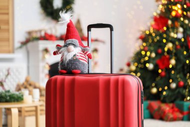 Bulanık ışıklara karşı evde dekoratif cüceyle dolu bavul, yakın plan. Noel tatili