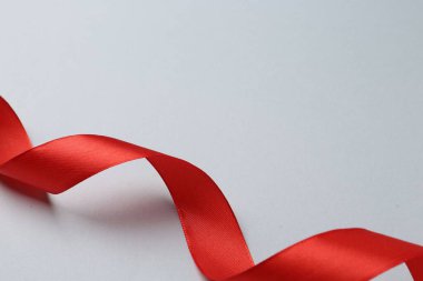 Işıklı arka planda güzel kırmızı kurdele, yakın plan. Metin için boşluk