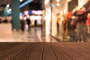 Boş ahşap masa, bulanık alışveriş merkezi manzarasına karşı. Tasarım için boşluk
