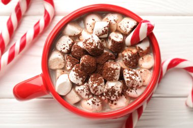 Lezzetli kakao, lokum ve beyaz ahşap masa üzerinde şeker kamışı, düz yatak. Noel atmosferi