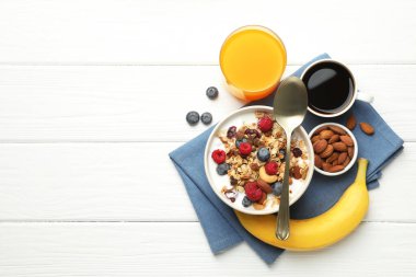 Sağlıklı kahvaltı. Fındıklı yulaf ezmesi, böğürtlen ve süt beyaz ahşap masada servis edilir. Metin için boşluk