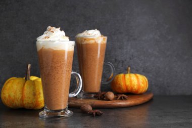 Krem şanti, baharat ve taze sebzeli balkabaklı latte, koyu dokulu masa, yakın plan. Metin için boşluk