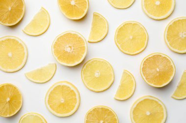 Beyaz arka planda taze limon parçaları, düz uzanmış.