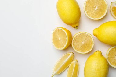 Beyaz arka planda taze olgun limonlar, düz uzanmış. Metin için boşluk