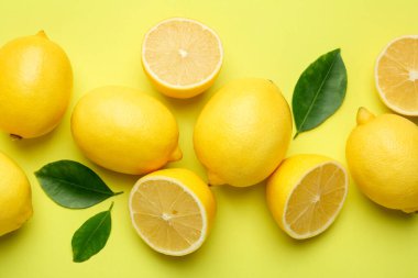 Taze olgun limonlar ve sarı arka planda yapraklar.