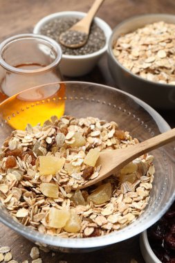 Tahıl yapıyorum. Tahta masada kurumuş meyveli yulaf gevrekleri, yakın plan.