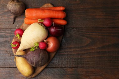 Ahşap masada farklı çiğ sebzeler, üst manzara. Metin için boşluk
