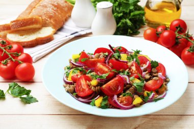 Lezzetli mercimek salatası ve malzemeler açık ahşap masada, yakın plan.