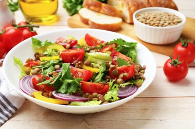 Lezzetli mercimek salatası ve malzemeler açık ahşap masada, yakın plan.