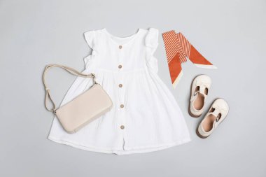 Şık çocuk kıyafetleri, ayakkabıları ve parlak arka planda çanta, düz yatış