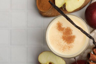 Lezzetli protein karışımı cam, elma, tarçın ve vanilya kabukları beyaz fayanslı masa, düz yatak. Metin için boşluk