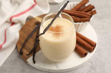 Lezzetli protein karışımı. Gri masada tarçın ve vanilya kapsülleri. Yakın plan.