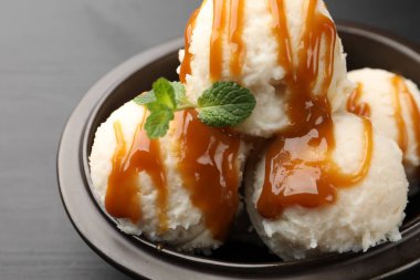 Karamel soslu lezzetli dondurma ve siyah masada nane şekeri.