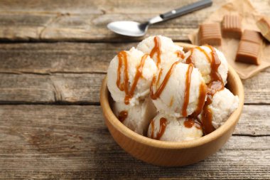 Tahta masadaki kasede karamel soslu lezzetli dondurma, yakın plan. Metin için boşluk