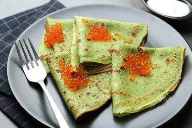 Kırmızı havyarlı ve ekşi kremalı ıspanaklı krep, yakın plan.