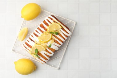 Lezzetli limonlu pasta, taze meyve dilimleri ve beyaz fayanslı masada nane şekeri, düz yatak. Metin için boşluk