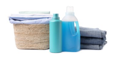 Çamaşır sepetinde beyaza izole edilmiş giysiler ve şişe deterjan.