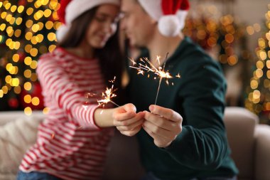 Noel Baba şapkalı, pırıltılı, seçici odaklı sevimli bir çift. Mutlu Noeller ve mutlu yıllar.