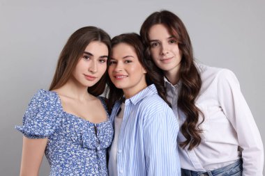 Gri arkaplanda üç arkadaşın portresi