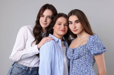 Gri arkaplanda üç arkadaşın portresi