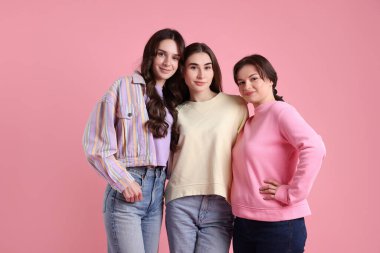 Pembe arka planda üç arkadaşın portresi