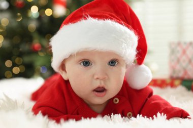 Evde, Noel Baba şapkalı şirin bir bebek. Noel sezonu