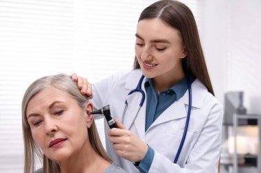 Duyma testi. Klinikte hastanın kulağını yıldız falıyla muayene eden doktor, yakın plan.