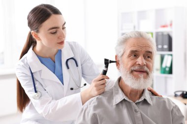 Duyma testi. Klinikte hastanın kulağını yıldız falıyla muayene eden doktor.