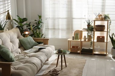 Kanepesi ve çiçekleri olan şık bir oturma odası. İç tasarım