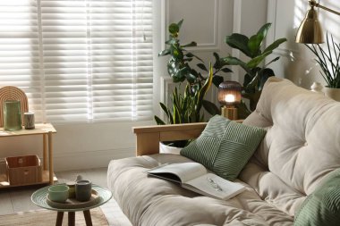 Kanepesi ve çiçekleri olan şık bir oturma odası. İç tasarım