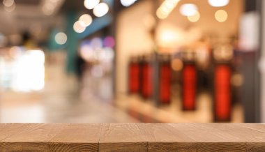 Boş ahşap masa, bulanık alışveriş merkezi manzarasına karşı. Tasarım için boşluk