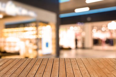 Boş ahşap masa, bulanık alışveriş merkezi manzarasına karşı. Tasarım için boşluk