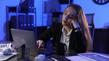 Uykulu kadın geceleri işyerinde esniyor.