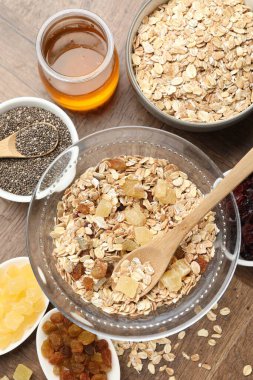 Tahıl yapıyorum. Yulaf gevreği, kurutulmuş meyve, chia tohumu ve bal ile ahşap masa üzerinde yassı kompozisyon