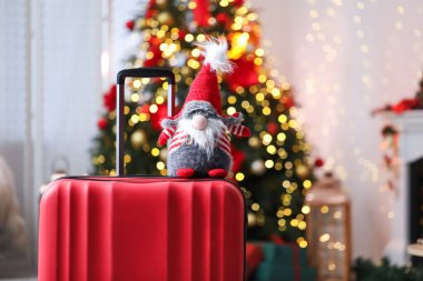 Bulanık ışıklara karşı evde dekoratif cüceyle dolu bavul, yakın plan. Noel tatili