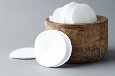 Açık gri arka planda temiz pamuk pedler, yakın plan. Metin için boşluk