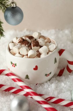 Marşmelovlu lezzetli kakao, baston şekerler ve yapay kar üzerine Noel dekoru, yakın plan.