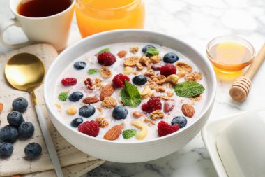 Sağlıklı kahvaltı. Fındıklı yulaf ezmesi, böğürtlen ve süt beyaz mermer masada, yakın plan.