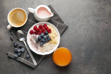 Sağlıklı kahvaltı. Fındıklı yulaf ezmesi, böğürtlen, yoğurt, chia tohumu, kahve ve portakal suyu gri desenli masa, düz yatak. Metin için boşluk