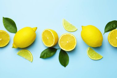 Taze olgun limonlar ve açık mavi arka planda yapraklar.