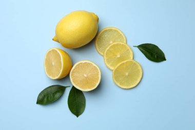 Taze olgun limonlar ve açık mavi arka planda yapraklar.