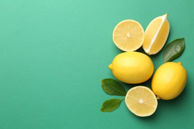 Taze limonlar ve yeşil arka planda yapraklar, düz. Metin için boşluk