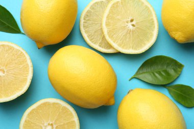 Taze olgun limonlar ve açık mavi arka planda yapraklar.