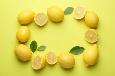 Taze olgun limonlardan yapılmış çerçeve ve sarı arka plandaki yapraklar düz. Metin için boşluk